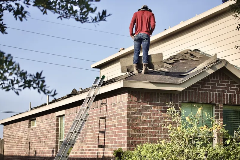 Professional roofer working on a residential roof in Tyrolian Village